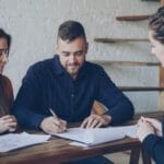 Młode małżeństwo omawia dokumenty majątkowe z doradcą